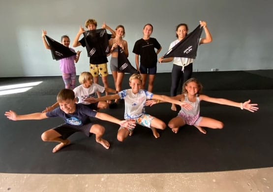 Nine young adolescents pose with Animal Flow bandanas