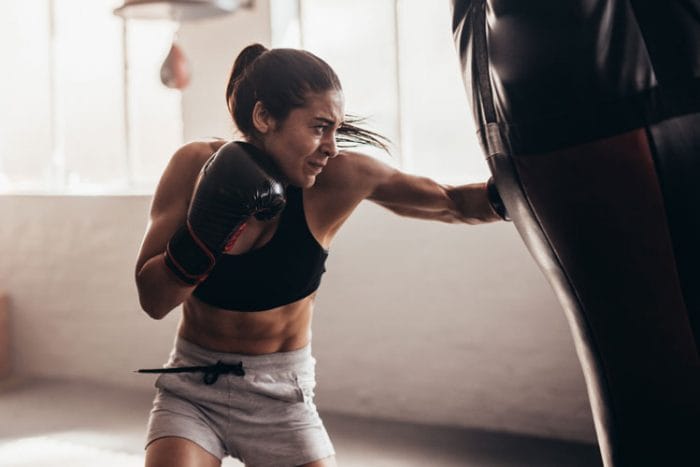 Woman throws a punch at a bag