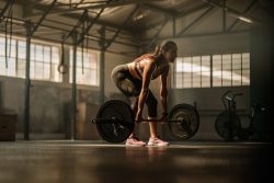 Woman deadlifting in warehouse